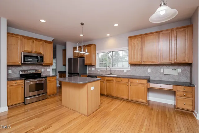 a kitchen with stainless steel appliances granite countertop a stove microwave refrigerator and cabinets