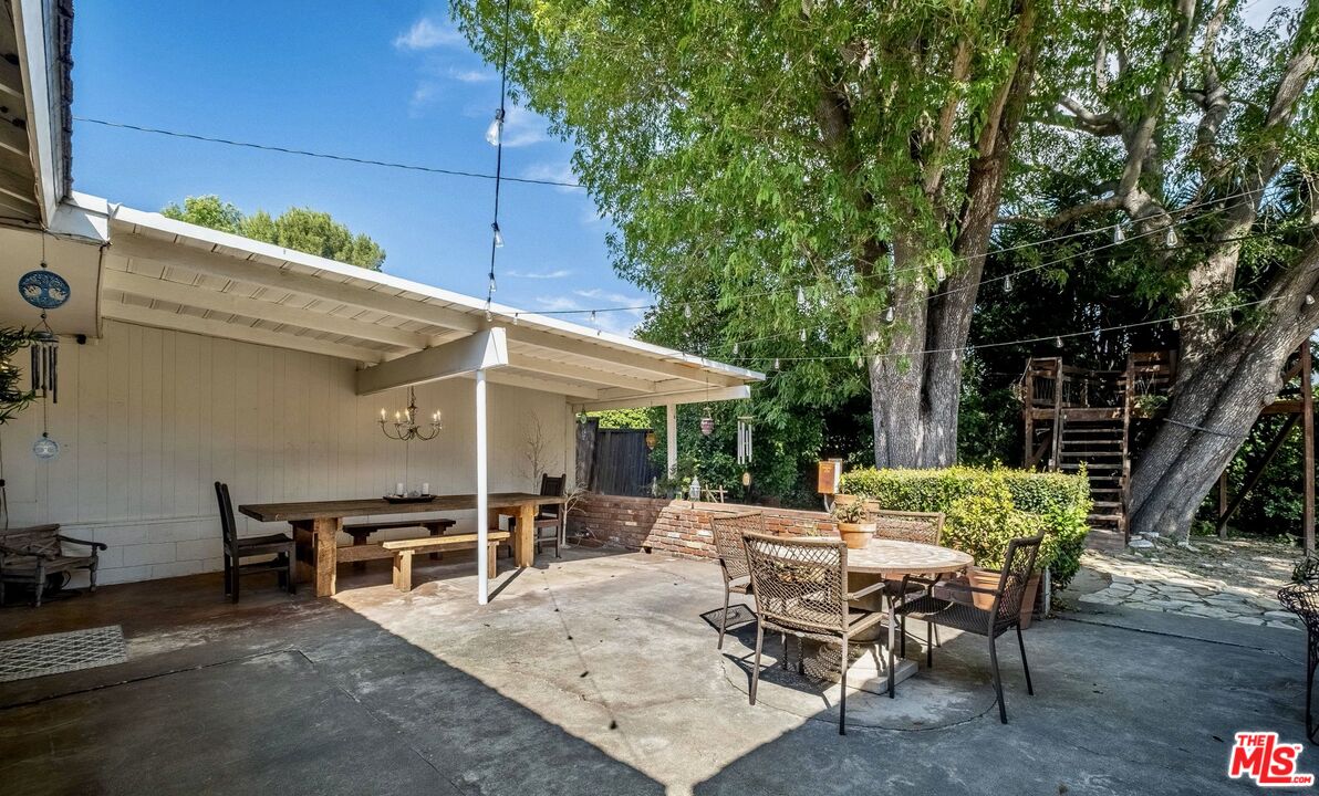 49 Ranchview Road Rolling Hills Estates, CA 90274 - Photo 35 of 49 a view of patio with table and chairs under an umbrella with large trees