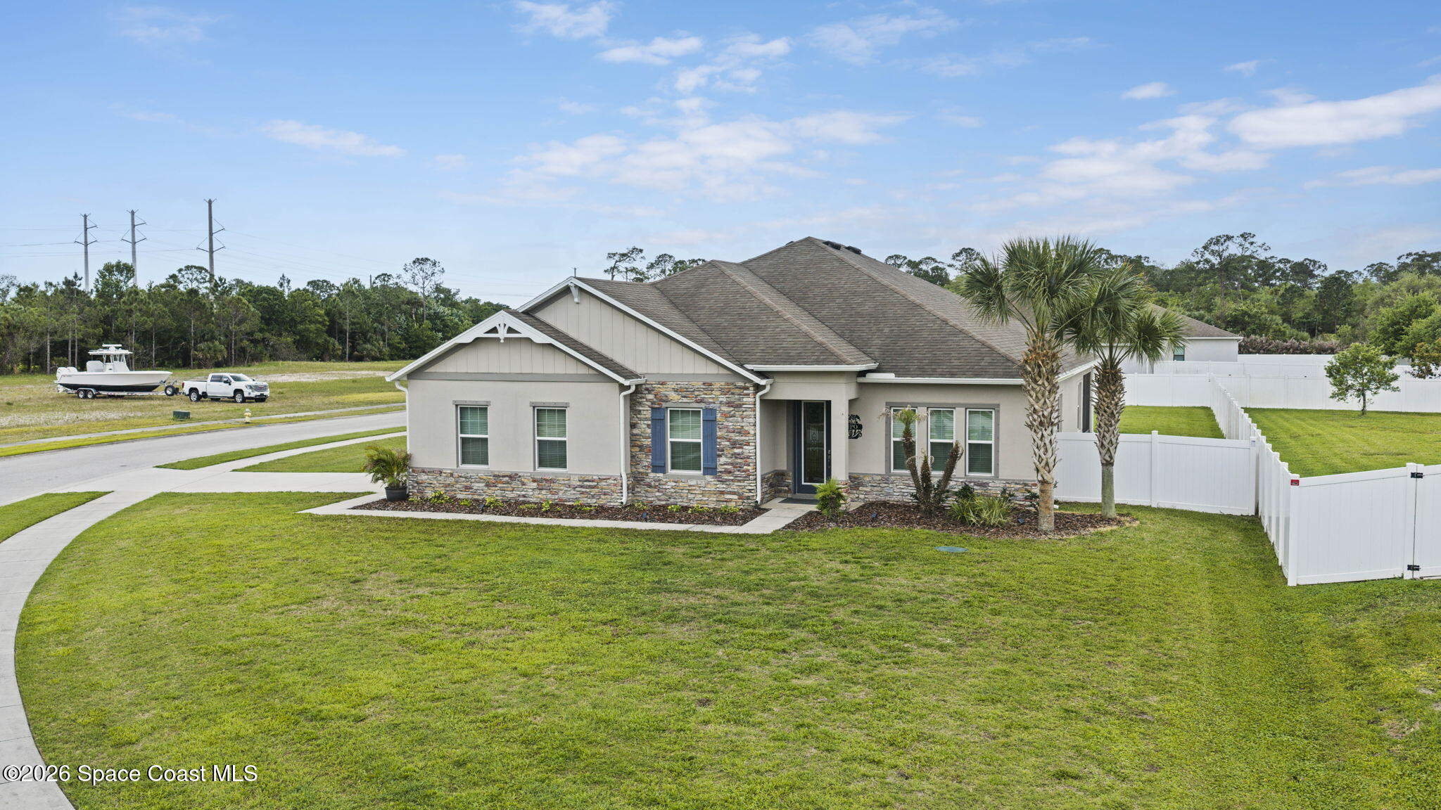 3441 Breezy Point Lane Cocoa, FL 32926 - Photo 2 of 8 a white house with a big yard and large trees