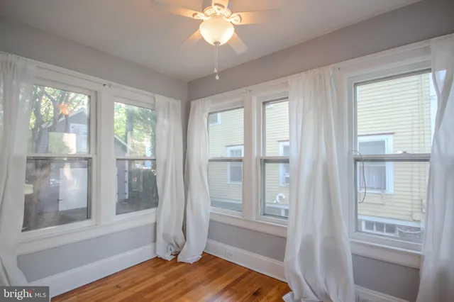 a view of a livingroom with wooden floor and a large window