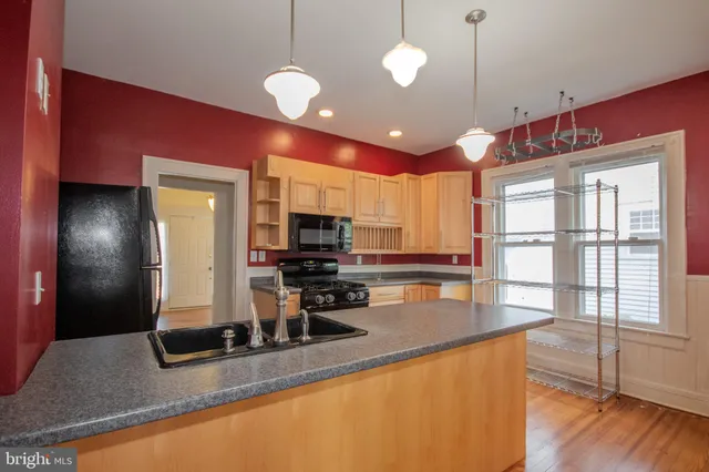 a kitchen with stainless steel appliances granite countertop a sink counter space and living room view