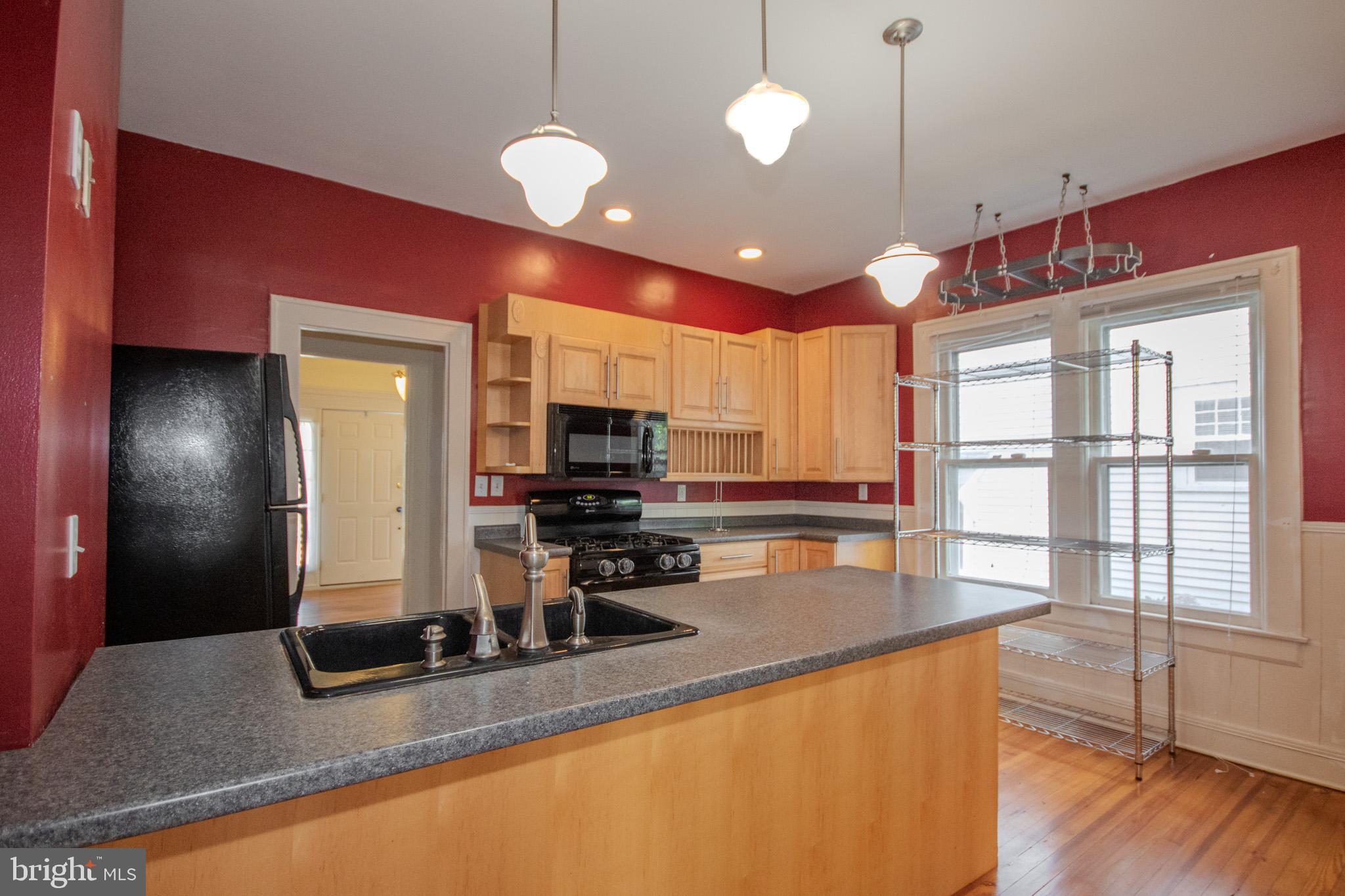 309 Gay Street Salisbury, MD 21801 - Photo 15 of 54 a kitchen with stainless steel appliances granite countertop a sink counter space and living room view