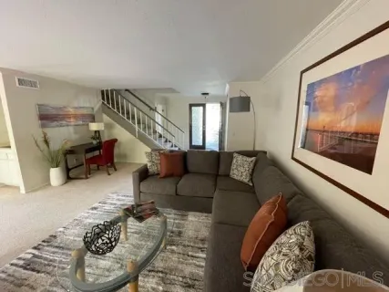 a living room with furniture and a painting on the wall