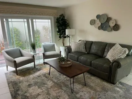 a living room with furniture lamp and window