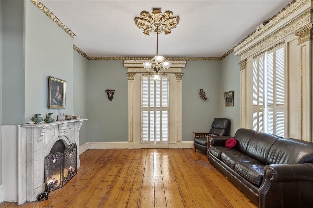 214 3rd Street, Unit A Lowell, MA 01850 - Photo 11 of 32 a living room with furniture a fireplace and a chandelier