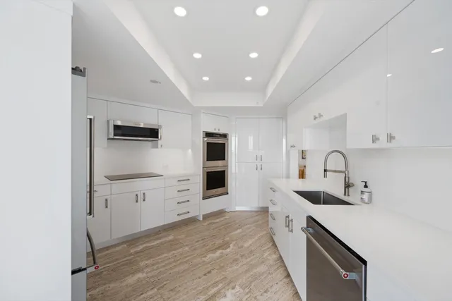a kitchen with granite countertop a sink stove and refrigerator