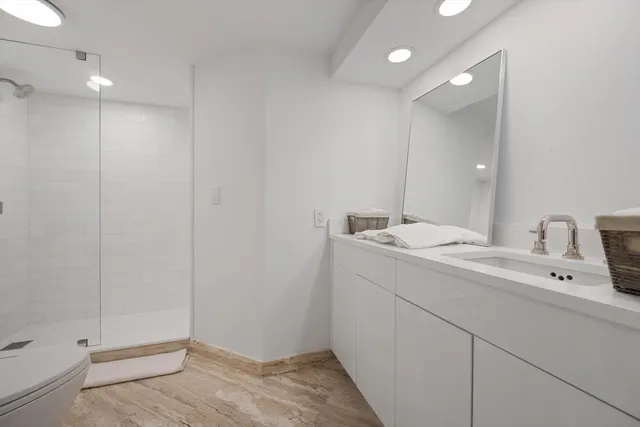 a bathroom with a sink a toilet and shower