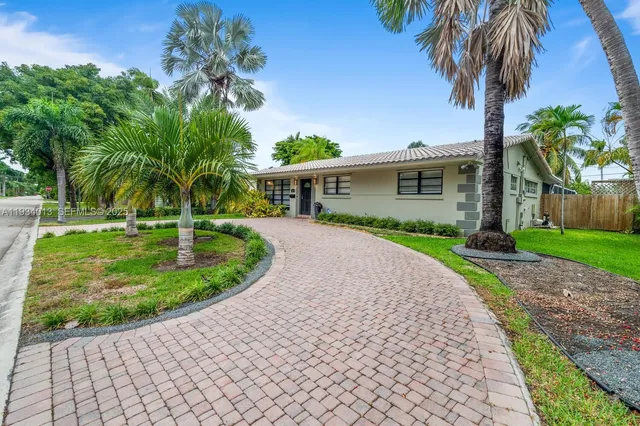 a front view of a house with a yard and potted plants