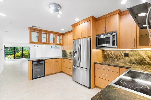 a kitchen with stainless steel appliances a refrigerator and a stove top oven