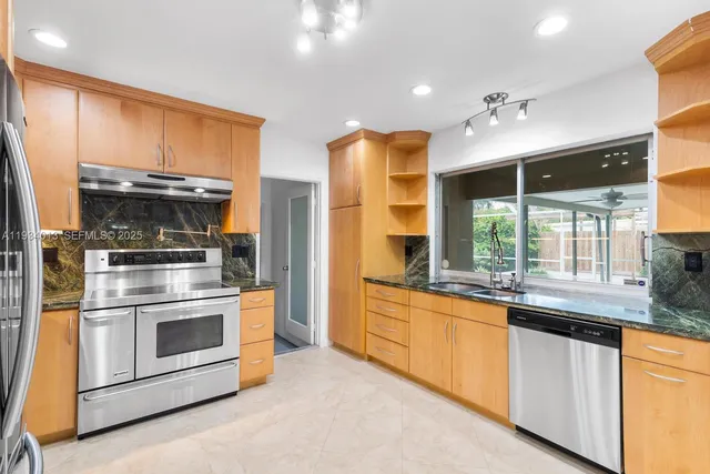 a kitchen with stainless steel appliances granite countertop a stove and a refrigerator