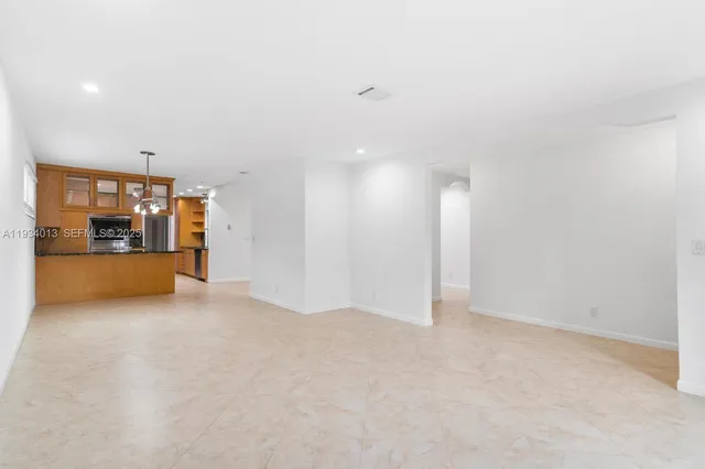 a view of an empty room with a kitchen