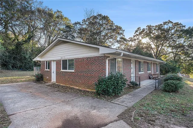 a front view of house with yard and trees in the background
