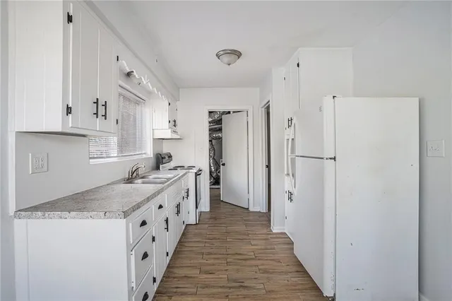a kitchen with white cabinets and sink