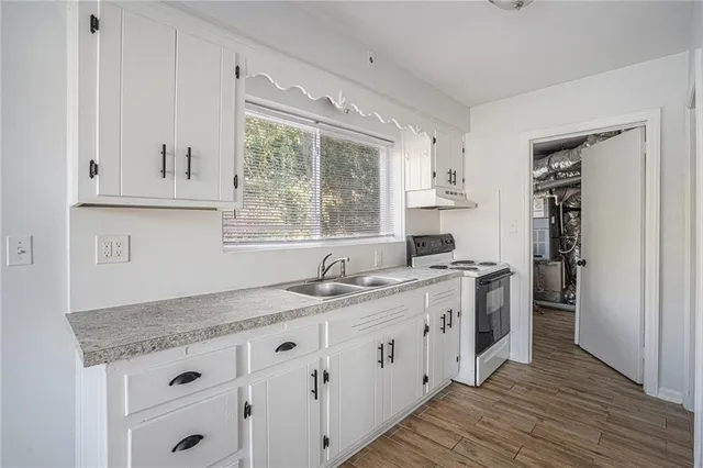 a kitchen with stainless steel appliances granite countertop a sink stove and cabinets