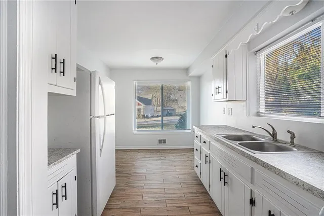 a open kitchen with granite countertop a sink and a refrigerator