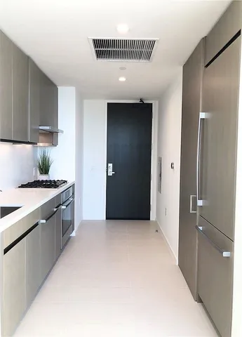 a large kitchen with a sink and stainless steel appliances
