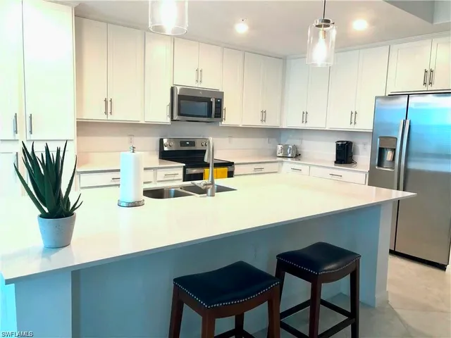 a kitchen with a sink a microwave and cabinets
