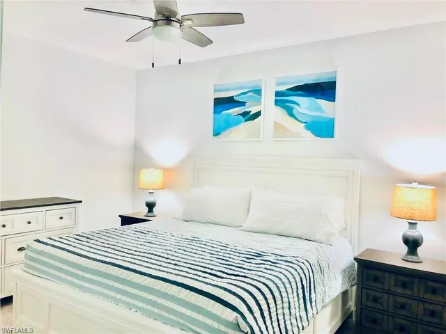 a bedroom with a bed and a lamp on dresser