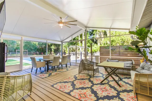 a view of swimming pool with lawn chairs and large trees