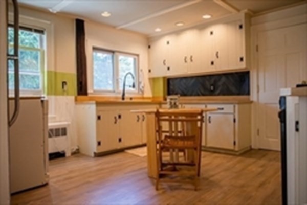 141 Hale Street, Unit 2 Beverly, MA 01915 - Photo 4 of 17 a kitchen with stainless steel appliances a stove a refrigerator a sink with white cabinets and wooden floor