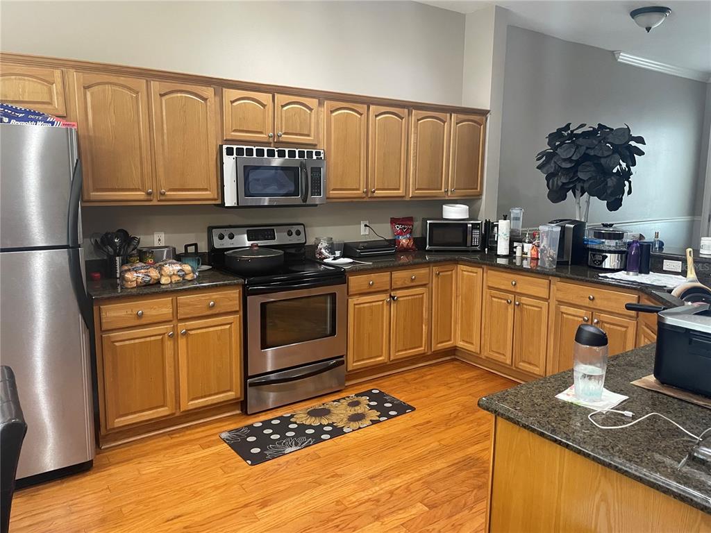 8405 Costa Bella Way Temple Terrace, FL 33637 - Photo 2 of 6 a kitchen with stainless steel appliances granite countertop a sink stove and refrigerator