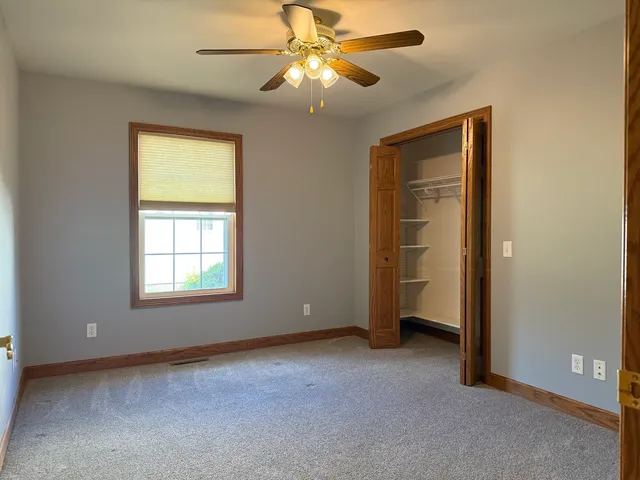 an empty room with windows and closet
