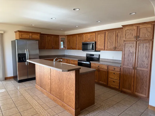 a kitchen with stainless steel appliances granite countertop a stove a sink and a refrigerator