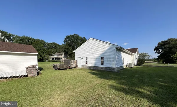 a view of a house with a big yard and large trees