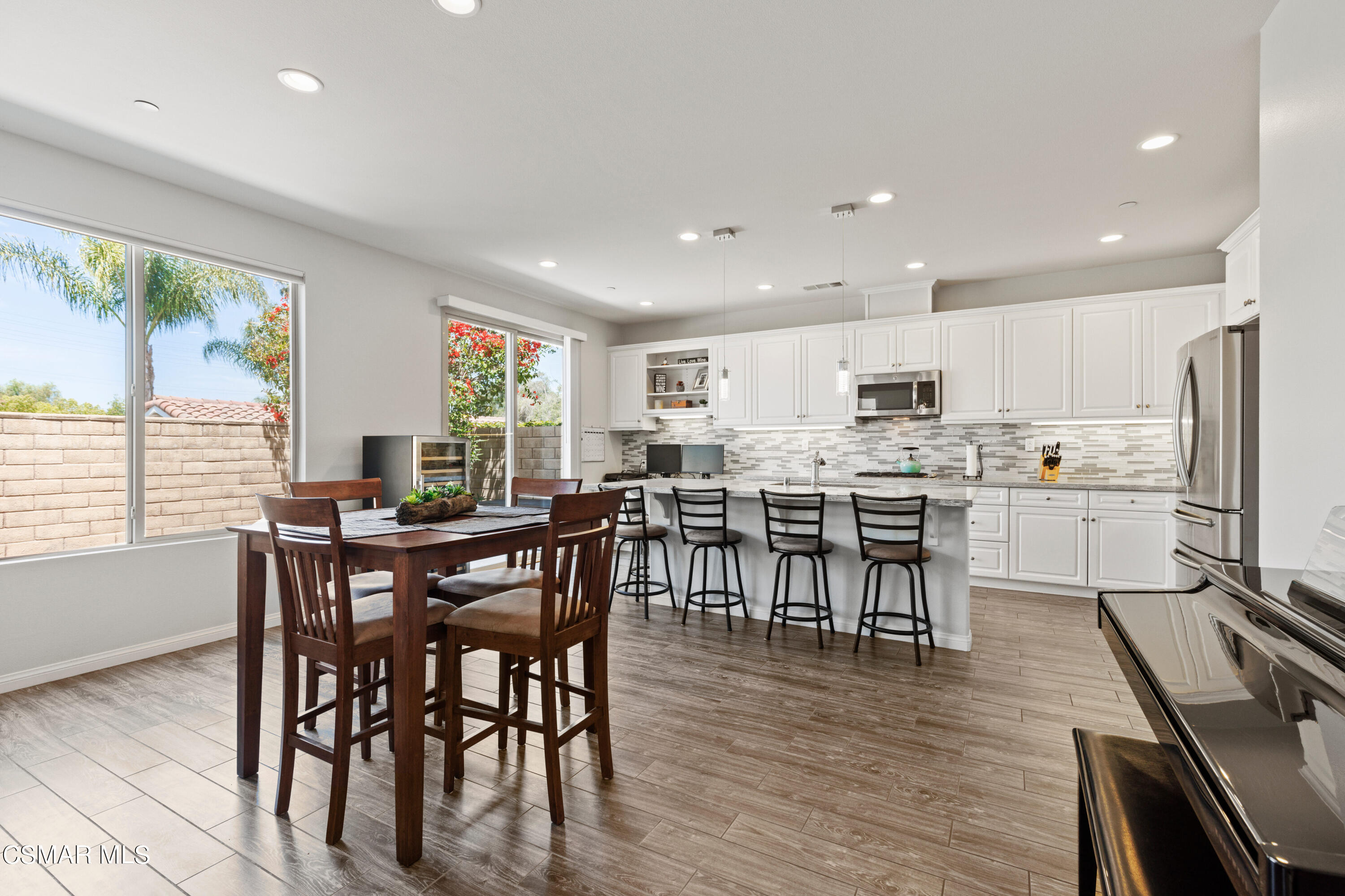 4893 Edenbridge Road Moorpark, CA 93021 - Photo 4 of 31 a open dining room with stainless steel appliances wooden floors a table and chairs