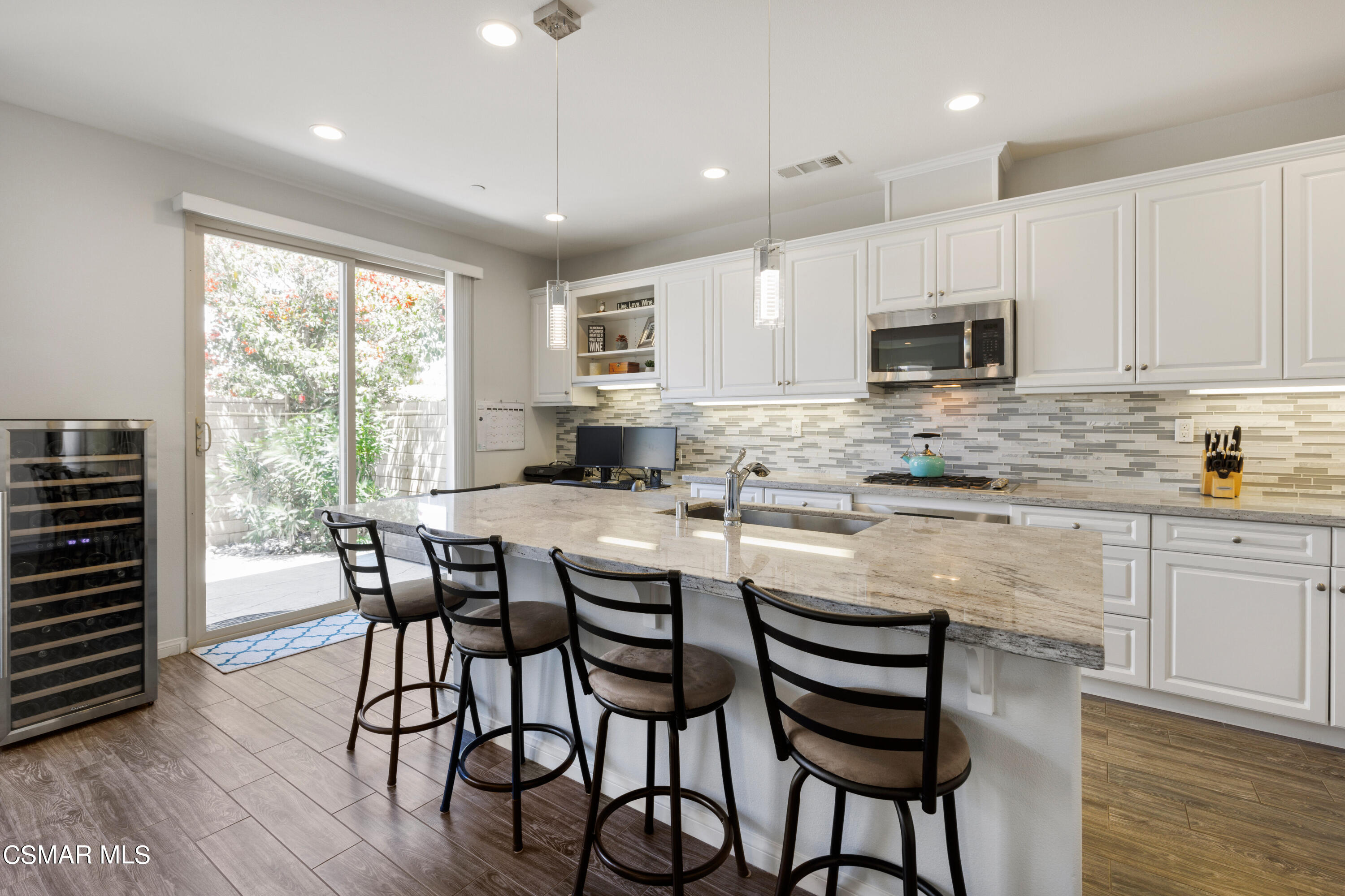 4893 Edenbridge Road Moorpark, CA 93021 - Photo 10 of 31 a kitchen with kitchen island granite countertop a table chairs microwave and cabinets