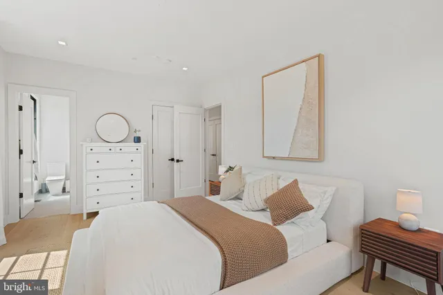 a bedroom with a bed a dresser and chair