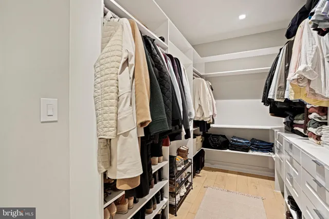 a view of walk in closet with clothes and shoes