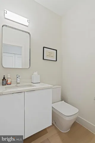 a bathroom with a toilet a sink a vanity and mirror