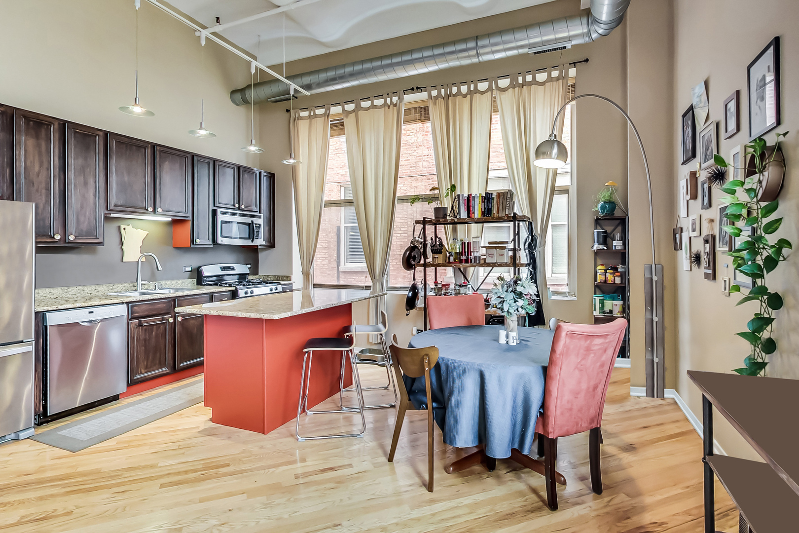 500 South Clinton Street, Unit 810 Chicago, IL 60607 - Photo 21 of 54 a large kitchen with stainless steel appliances granite countertop a stove a refrigerator a dining table and chairs