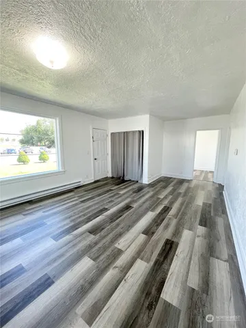 an empty room with wooden floor windows and outdoor view