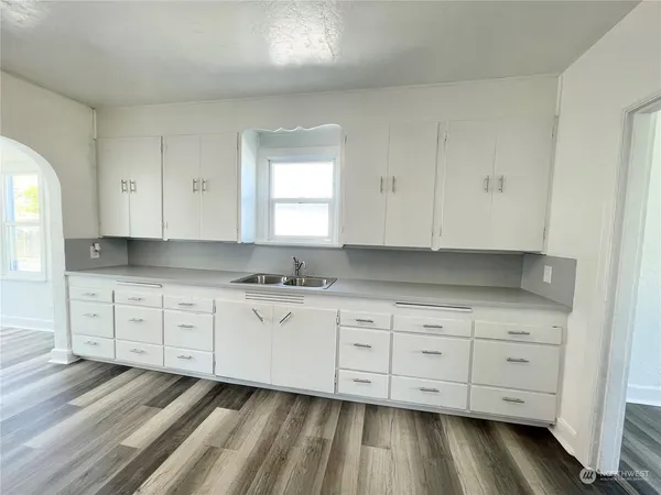 a room with granite countertop white cabinets and sink