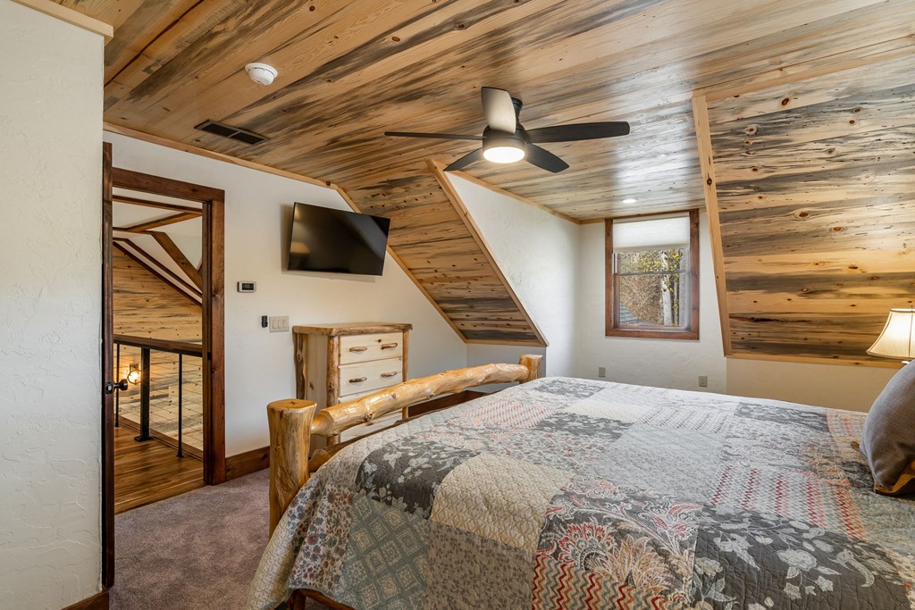 1248 Sunset Road Epworth, GA 30541 - Photo 37 of 65 a bedroom with a bed a flat screen tv cabinets and a window