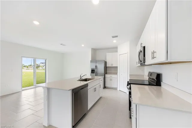a kitchen with stainless steel appliances a sink stove and cabinets