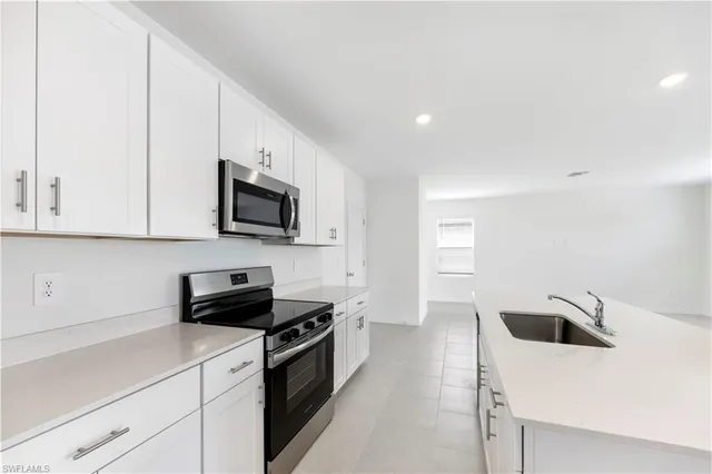 a kitchen with a sink a stove and microwave