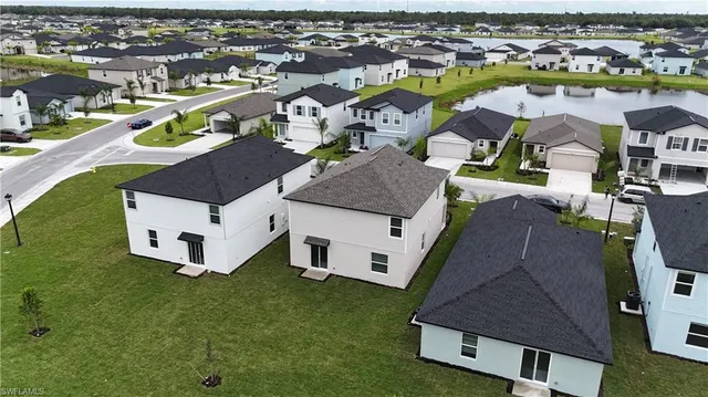 an aerial view of residential houses with outdoor space and pool