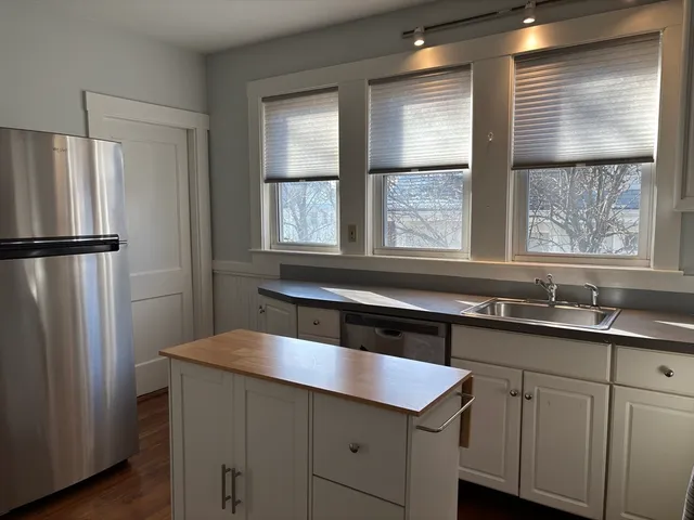 a kitchen with a sink a refrigerator and window
