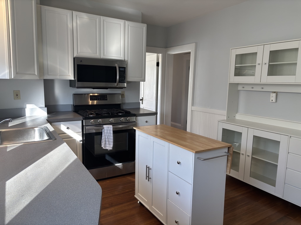 54-56 Farragut Avenue, Unit 2 Somerville, MA 02144 - Photo 12 of 30 a kitchen with a stove and a microwave