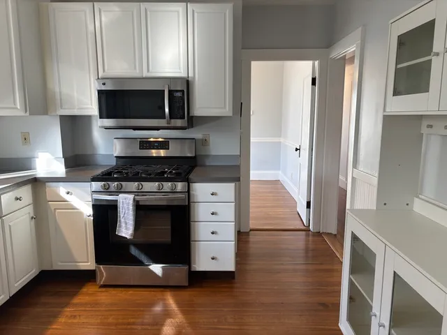 a kitchen with white cabinets and stainless steel appliances