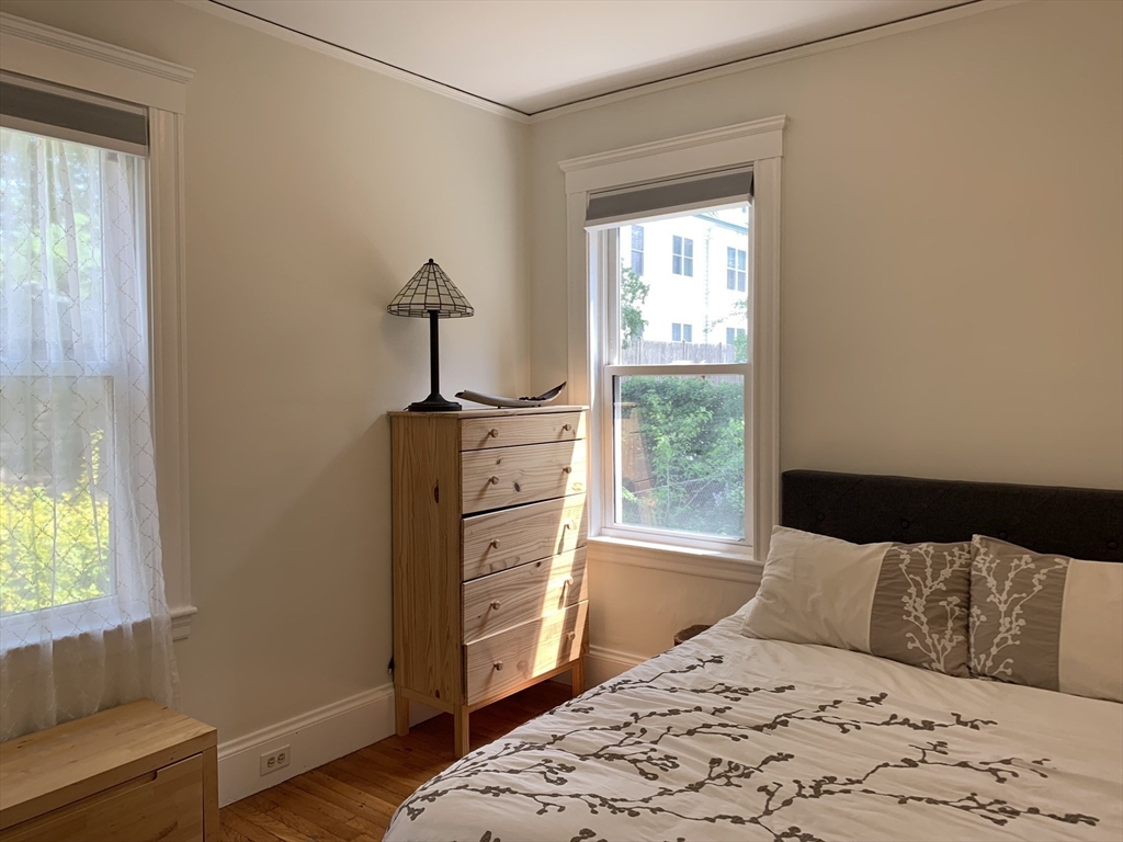 54-56 Farragut Avenue, Unit 2 Somerville, MA 02144 - Photo 15 of 30 a bedroom with a bed and wooden floor