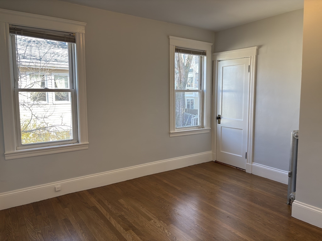 54-56 Farragut Avenue, Unit 2 Somerville, MA 02144 - Photo 21 of 30 an empty room with wooden floor and windows