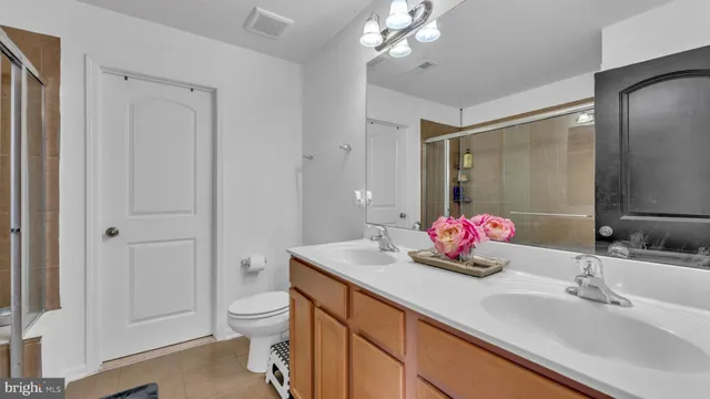 a bathroom with a glass shower door and a sink