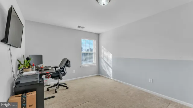 a view of a workspace with furniture and a window