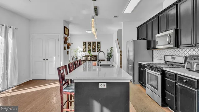 a kitchen with stainless steel appliances granite countertop a stove refrigerator sink and cabinets