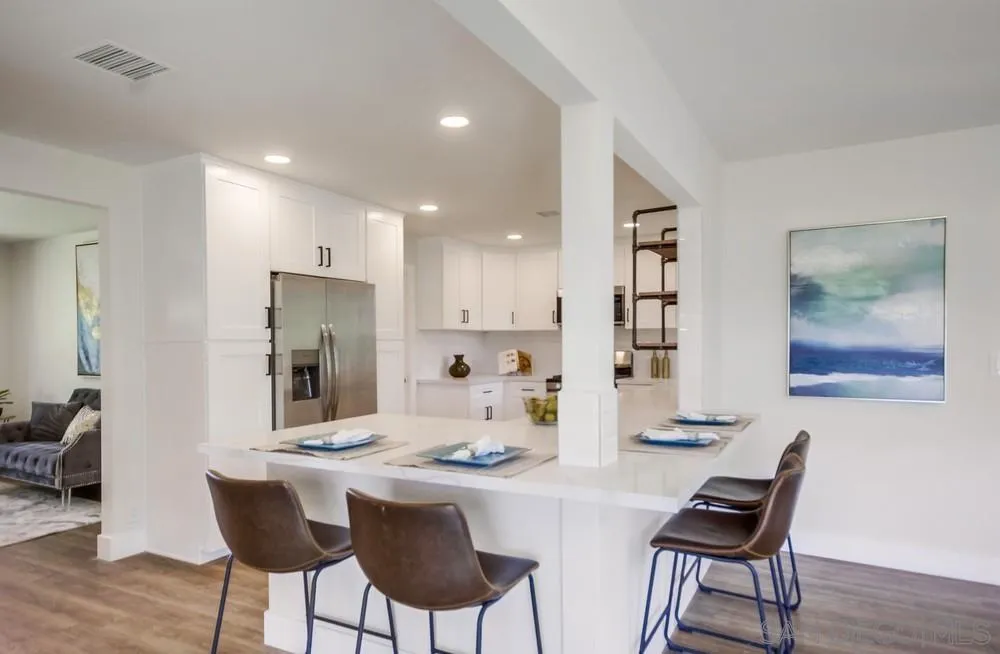 9841 Settle Road Santee, CA 92071 - Photo 19 of 46 a kitchen with a dining table cabinets appliances and wooden floor