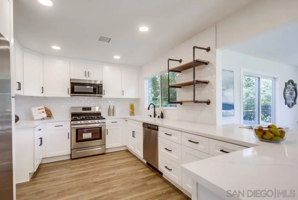 9841 Settle Road Santee, CA 92071 - Photo 24 of 46 a kitchen with stainless steel appliances white cabinets a sink a stove a refrigerator and a microwave